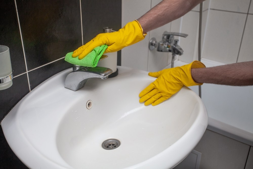 Reinigungskraft reinigt Badezimmer