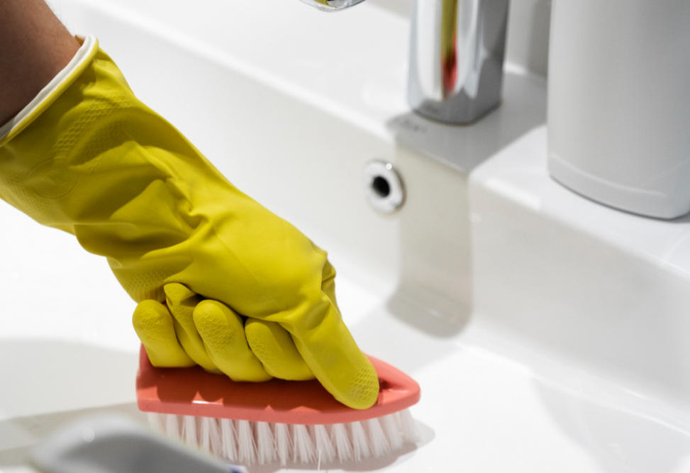 Reinigungskraft macht Sanitäranlagen sauber