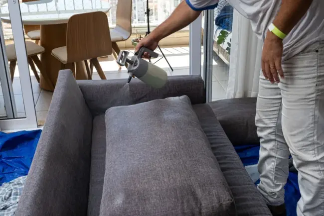 Reinigungskraft reinigt Couch Reinigungskraft reinigt Couch