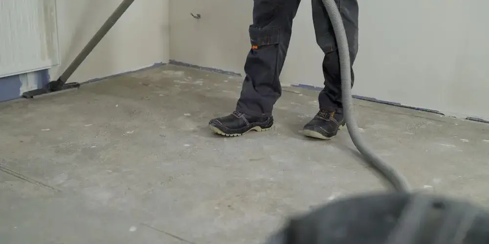 Reinigungskraft reinigt nach Bauarbeiten den Fussboden Reinigungskraft reinigt nach Bauarbeiten den Fussboden