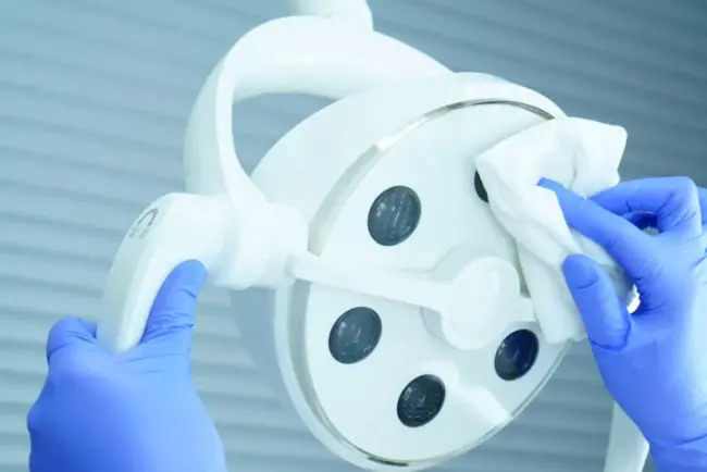 Reinigungskraft reinigt Praxisgerät