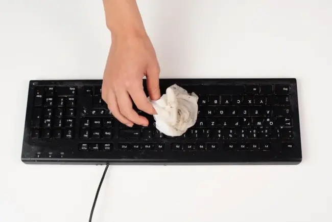 Mann reinigt die Computertastatur Mann reinigt die Computertastatur