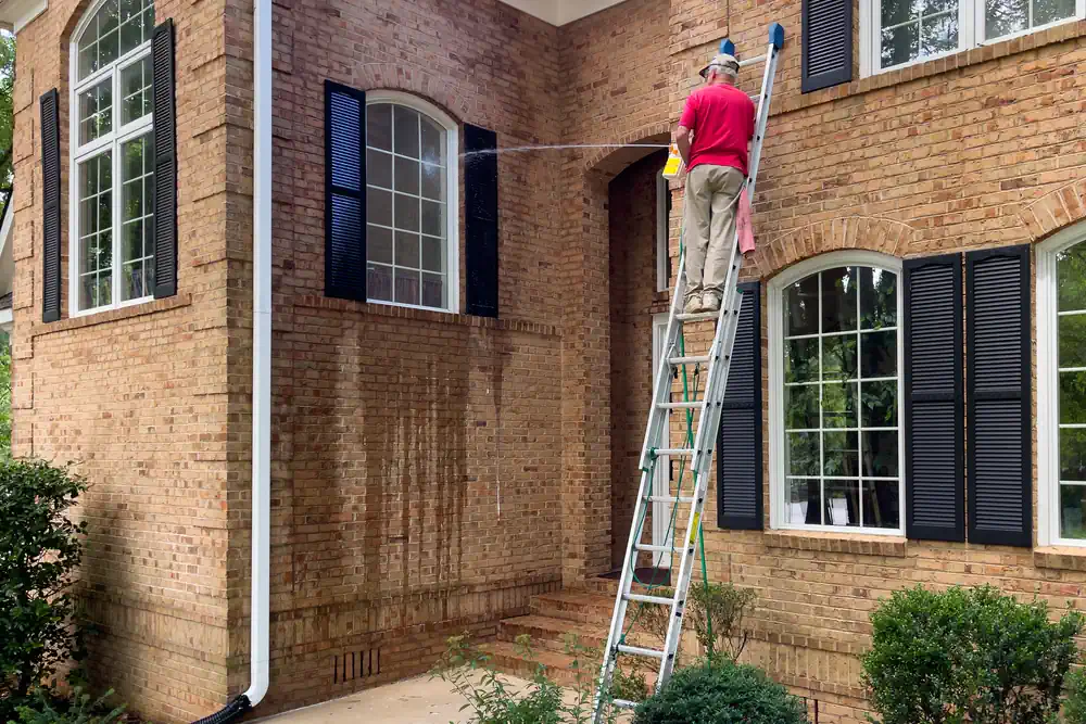 Mann verwendet zu viel Wasser beim Fensterreinigen