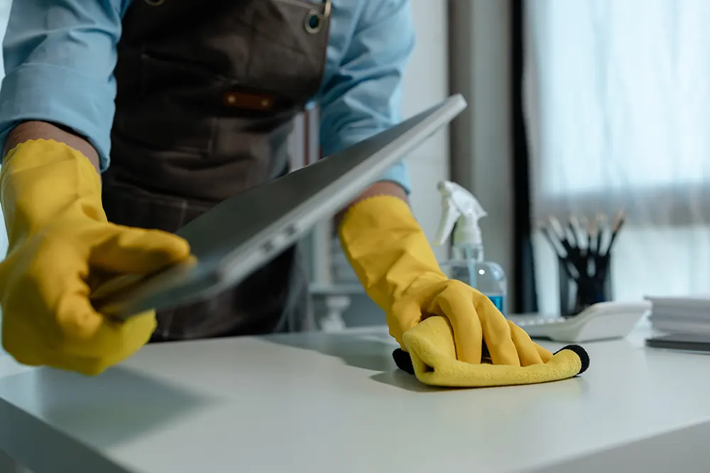 Reinigungskraft wischt Büro tisch