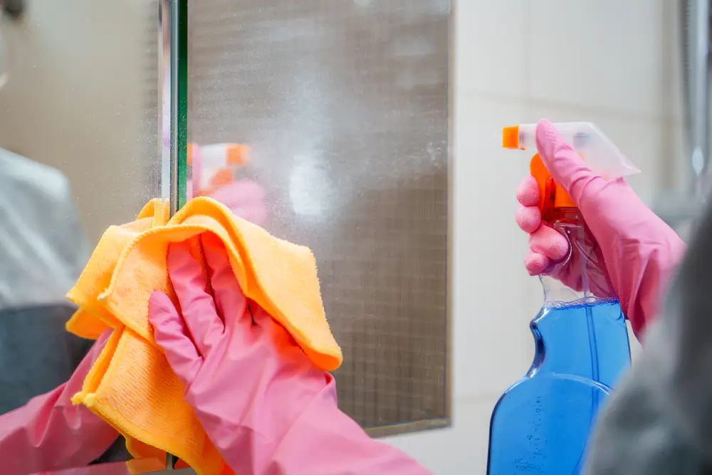 Mann putzt Wohnungsfenster